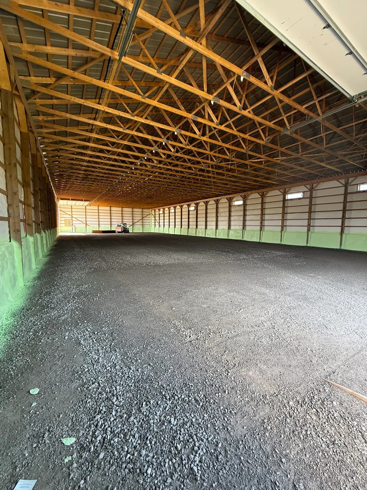 Large pole barn interior insulated with closed-cell spray foam at sunset