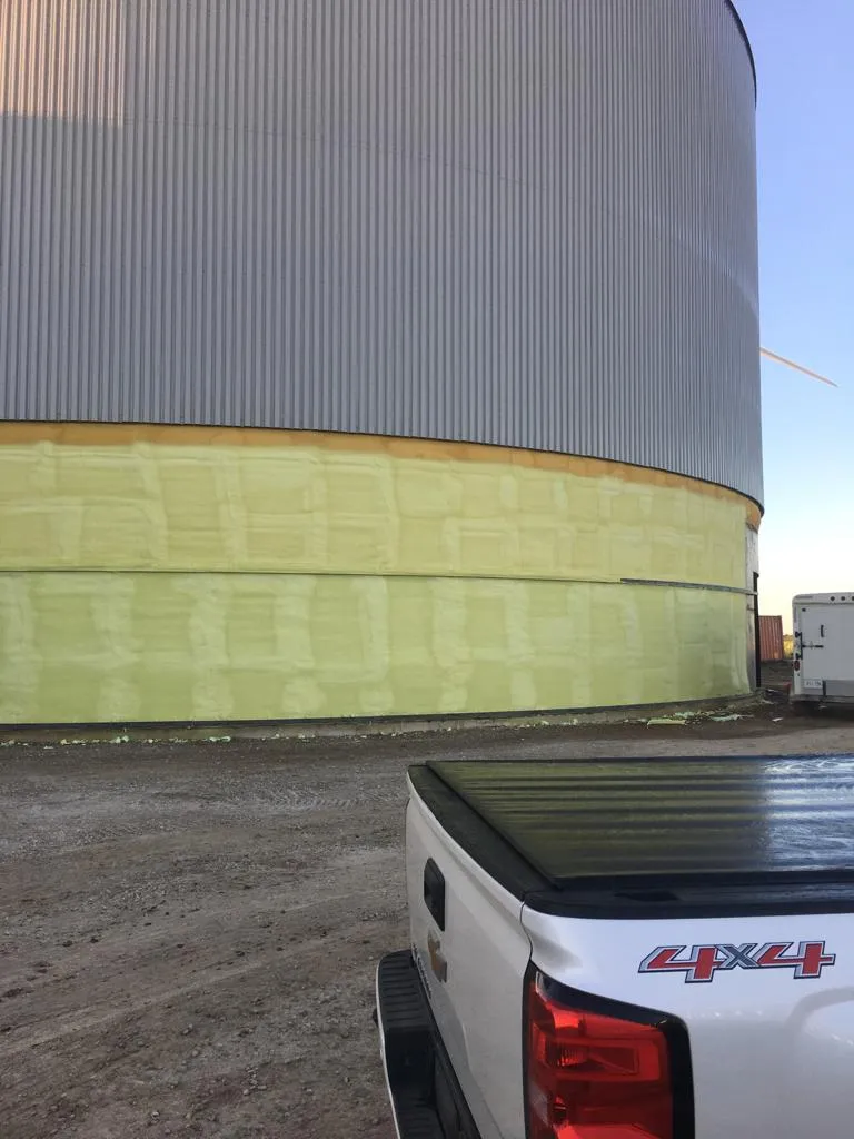 Greenhouse hot water storage tank with exterior closed-cell spray foam